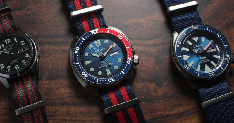 A close-up of a sports watch with a NATO watch strap in vibrant colours.