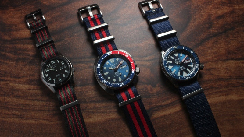 A close-up of a sports watch with a NATO watch strap in vibrant colours.